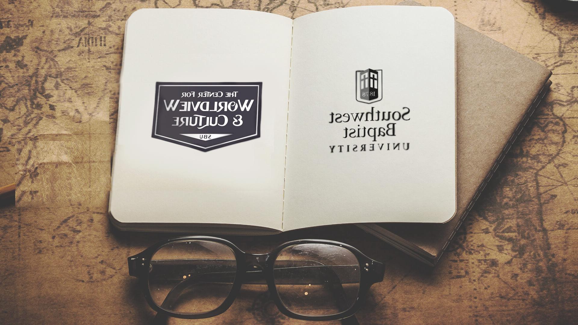 打开笔记本，旁边是折叠的眼镜，上面有S-B-U和世界观中心的标志
